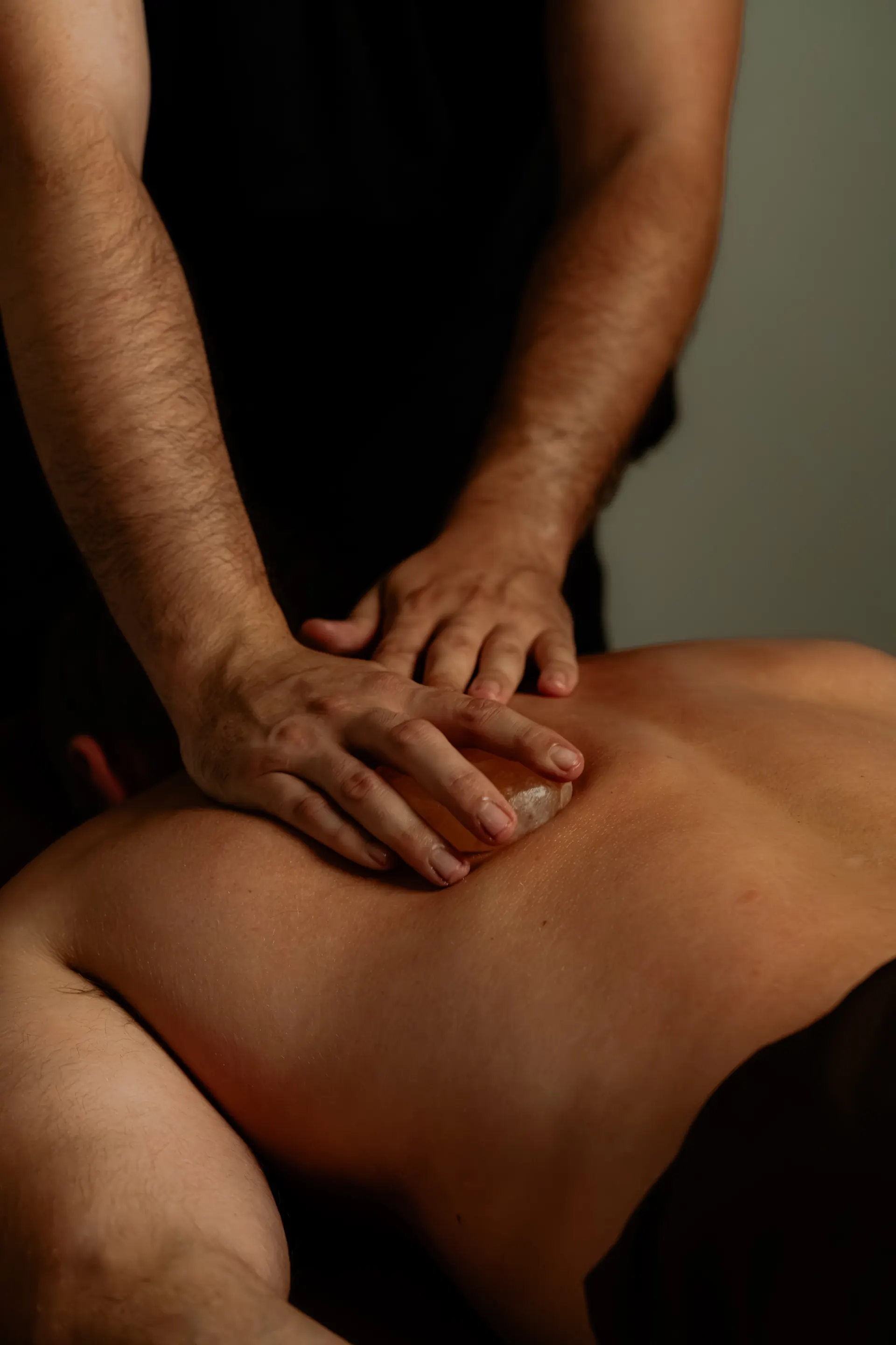 A massage therapist working a guest's shoulder