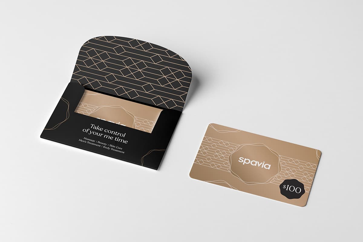 A gold Spavia gift card with its black patterned sleeve