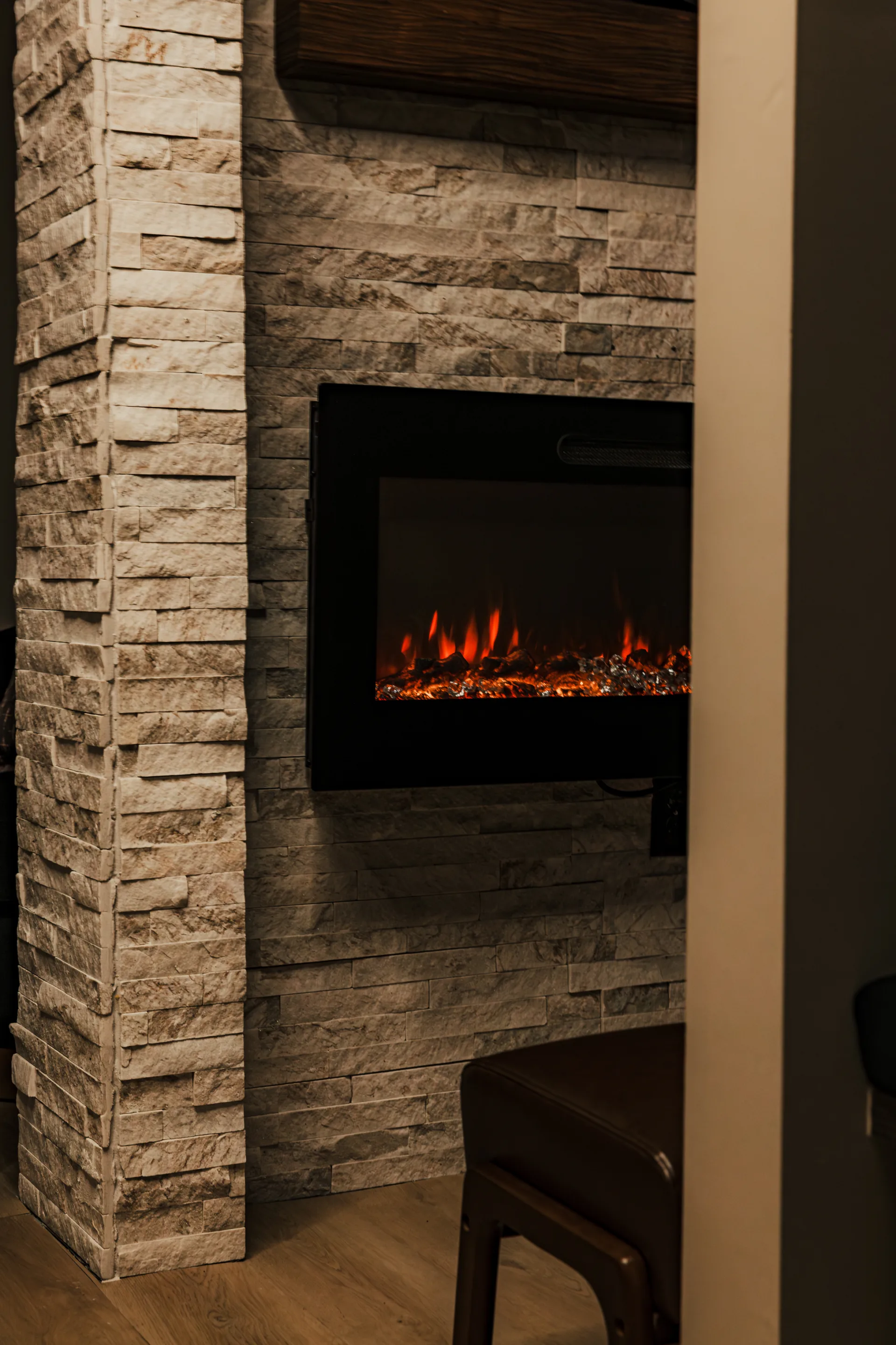 A fireplace glowing in a stacked-stone wall at Spavia Day Spa