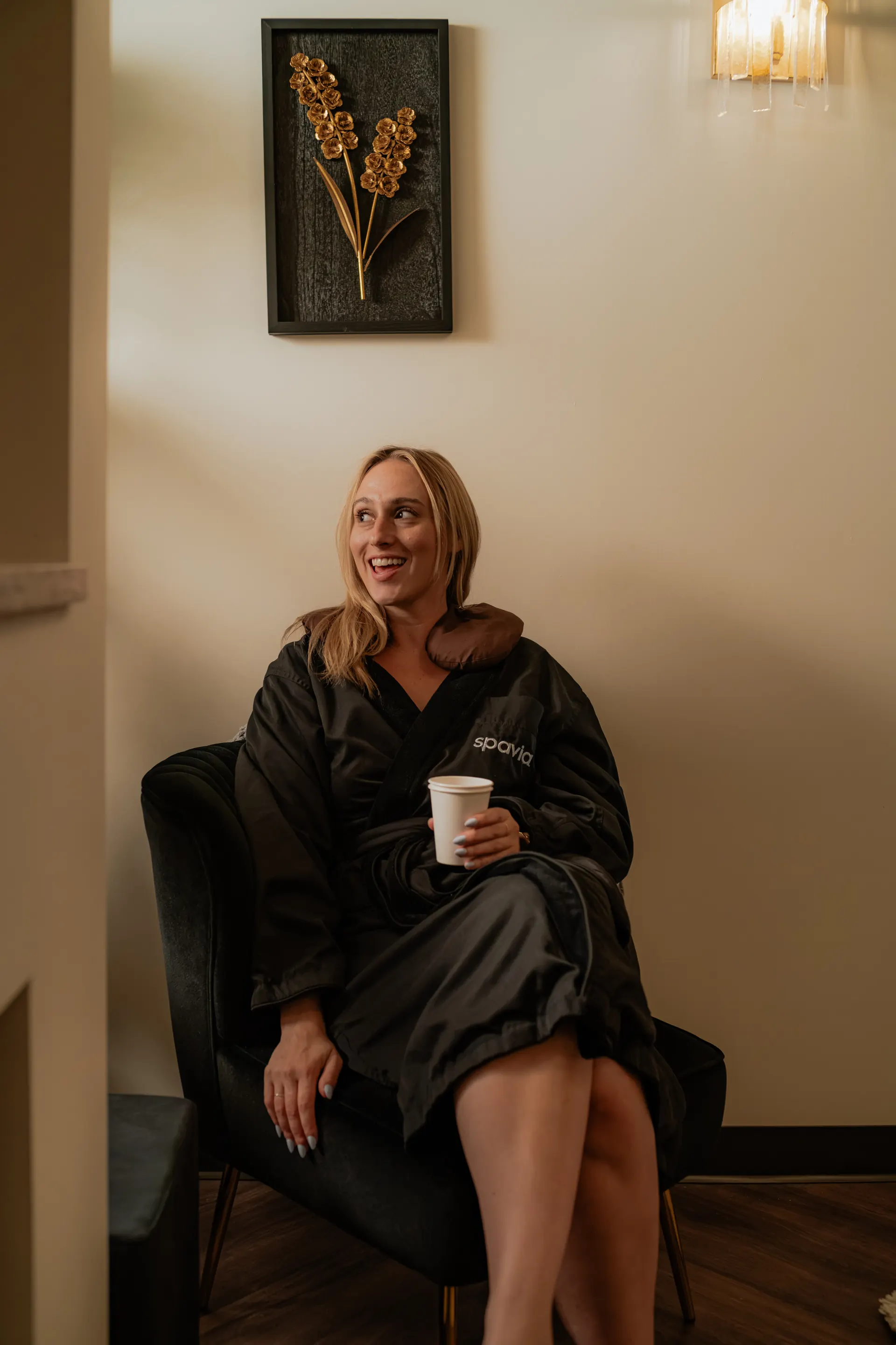 A guest in a Spavia robe and neck pillow relaxing in the Retreat Room