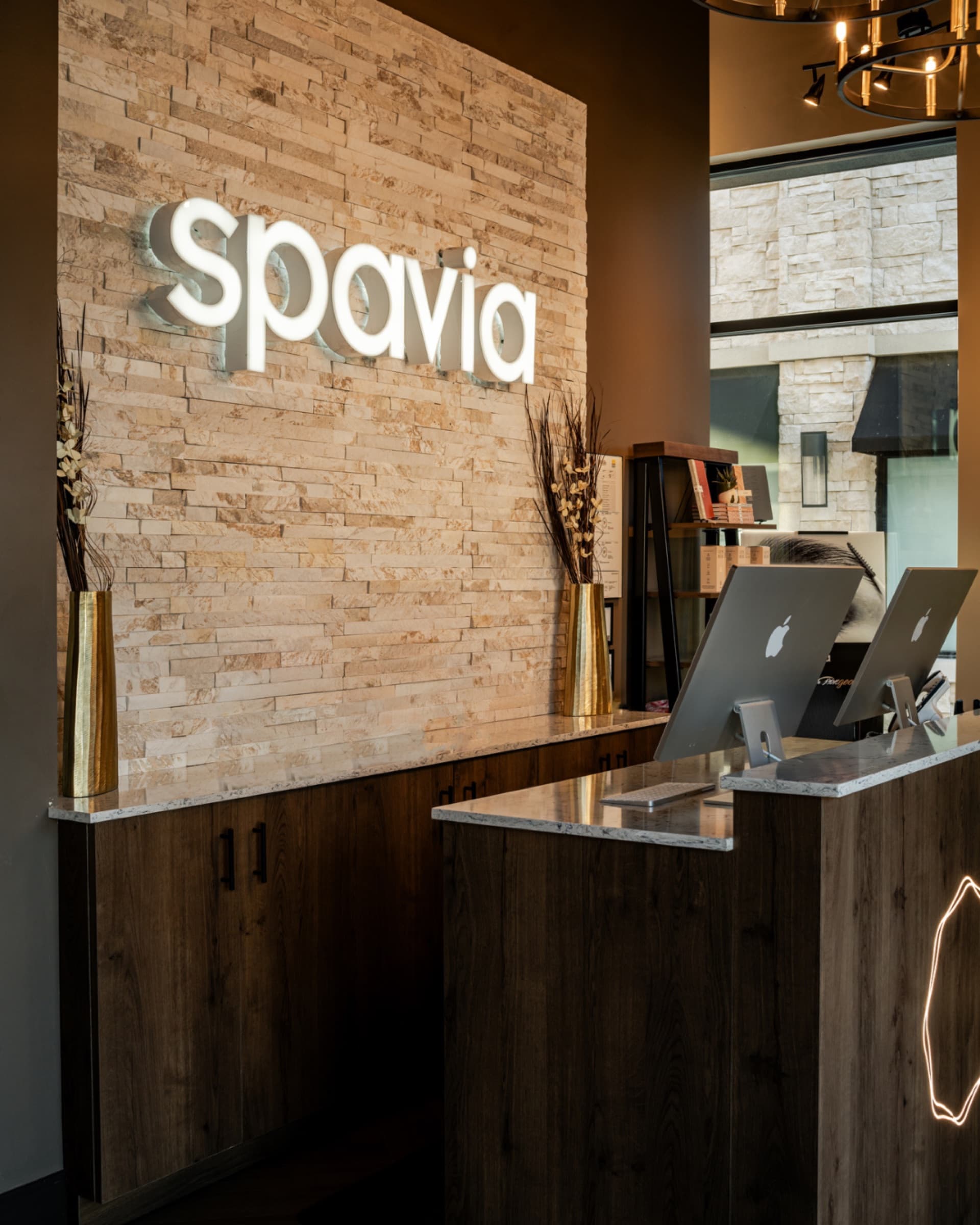 The Spavia wordmark behind a warmly lit reception desk