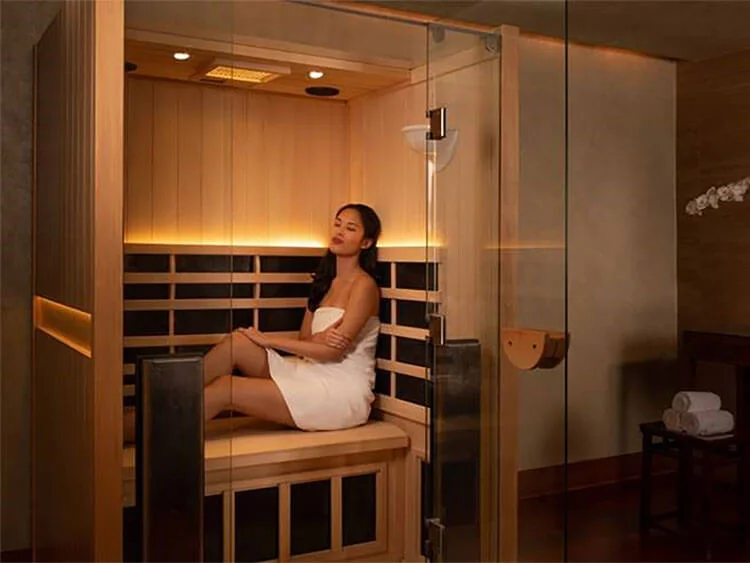 A guest relaxing in a towel in the infrared sauna