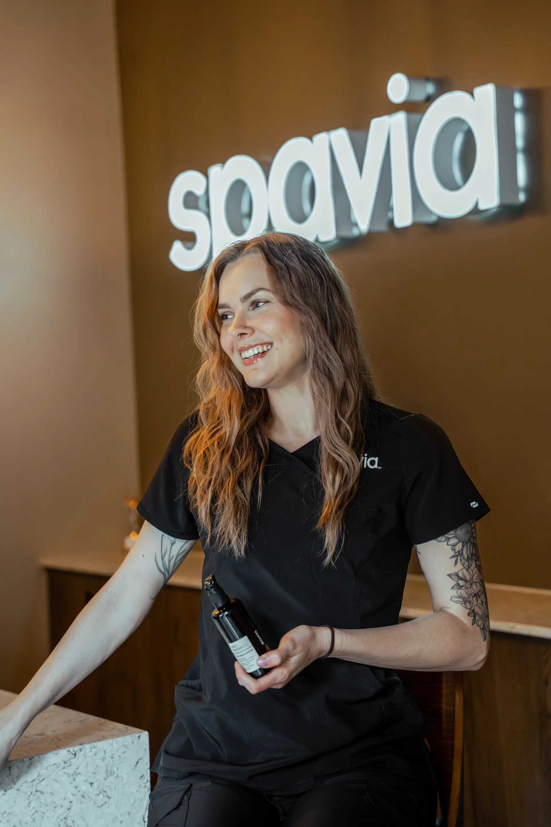 A smiling Spavia team member at the front desk of Spavia Belmar